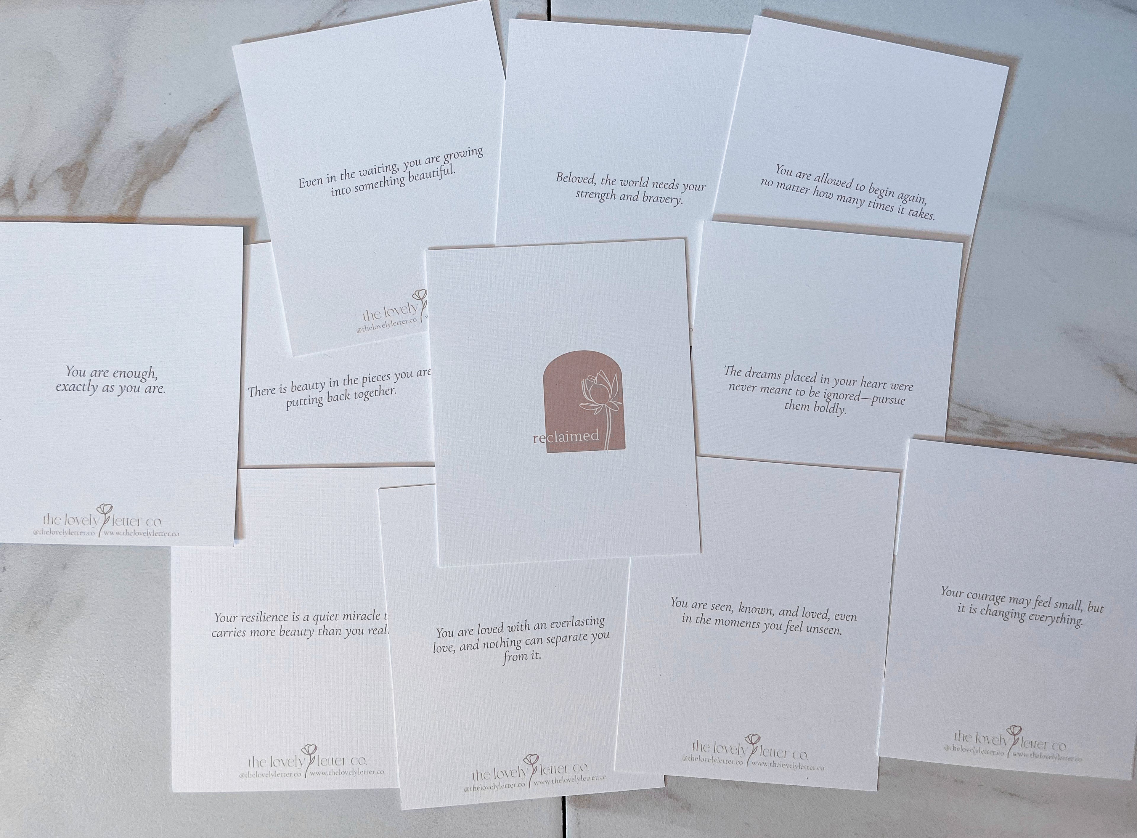 Set of white cards with text and a logo on a marble surface